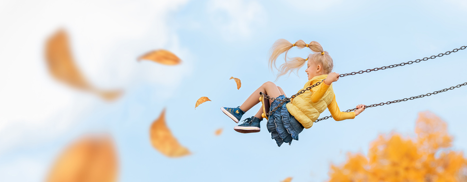 Girl on a swing with autumn foliage